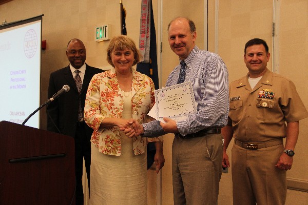 Duvall presents the June AFCEAN of the Month to Scott Rogers. Lt. Cmdr. Pereira, and ODU Student Chapter Lead Tim Goodrich stand witness.